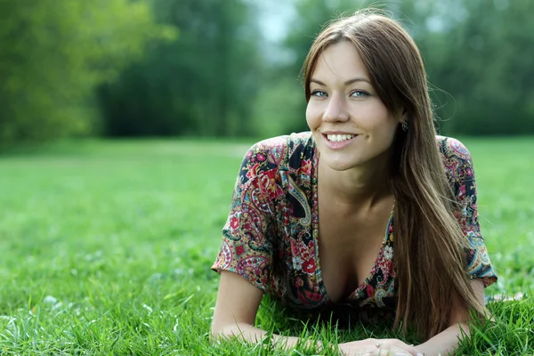 Ung kvinna avkopplande i gräset — Stockfoto