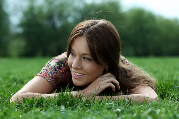 Jeune femme relaxante dans l'herbe — Photo