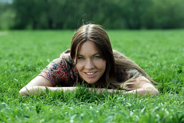 Jonge vrouw ontspannen in het gras — Stockfoto