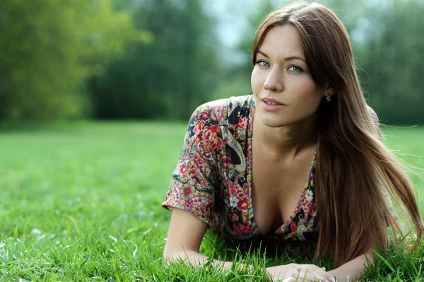 Genç kadın çimenlerde dinleniyor. — Stok fotoğraf