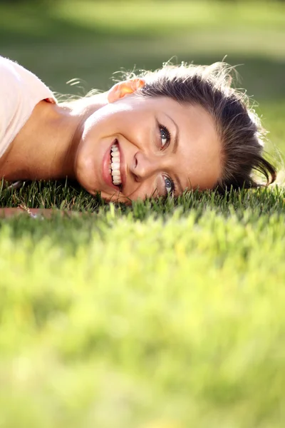 可爱的年轻女性，躺在草地上 — 图库照片