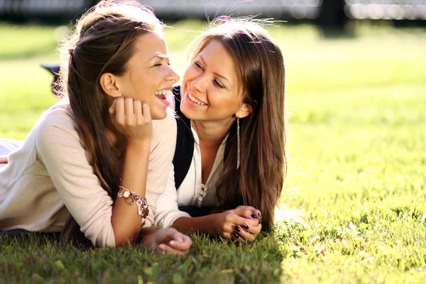 Beautiful twins of sister lays on green — Stock Photo, Image