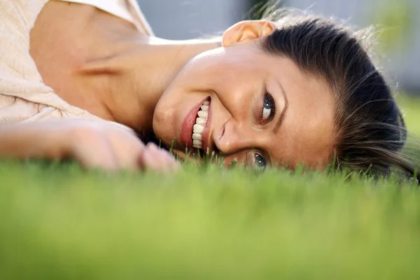 Schattige jonge vrouwelijke liggend op grasveld Stockfoto