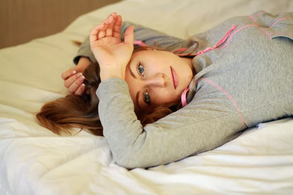 Genç kadın yatakta döşeme — Stok fotoğraf