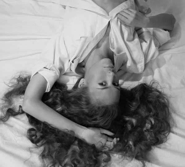 Yataklar üzerinde güzel bir kadın yatıyor — Stok fotoğraf