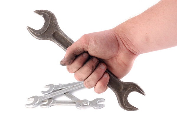 A metallic wrench is in a hand