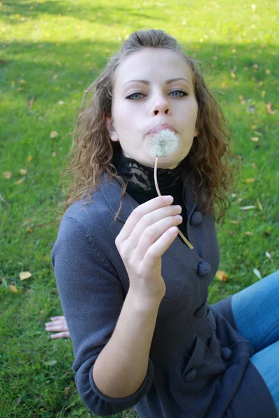 Girl holds a dandelion in the hand — Stock Photo, Image