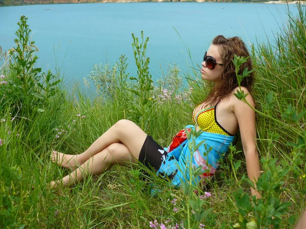 Chica se sienta cerca del mar azul —  Fotos de Stock