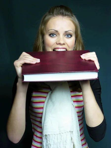 Blue-eyed student bites the book — Stock Photo, Image