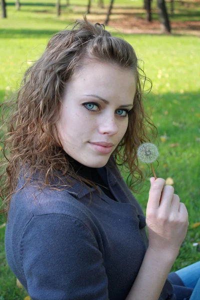 Girl holds a dandelion in a hand — Stock Photo, Image