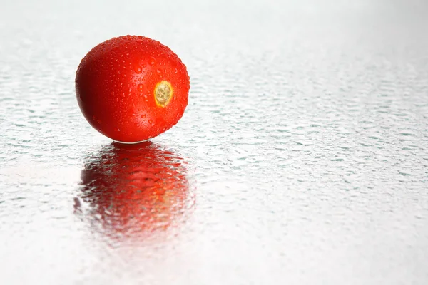 Tomato lies on the wet mirror — Stock Photo, Image