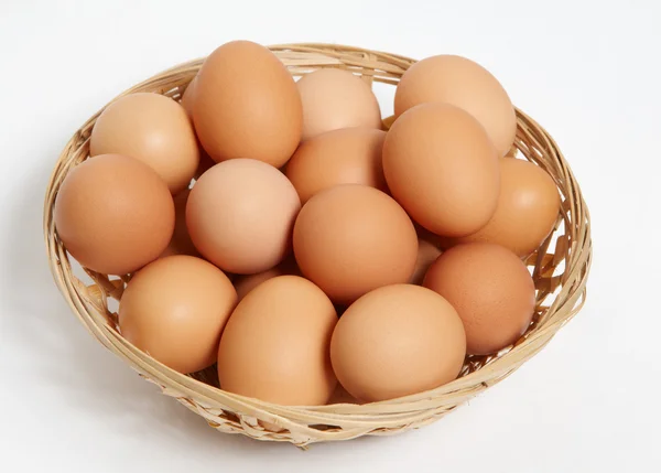 Basket of straw with eggs in white — Stock Photo, Image