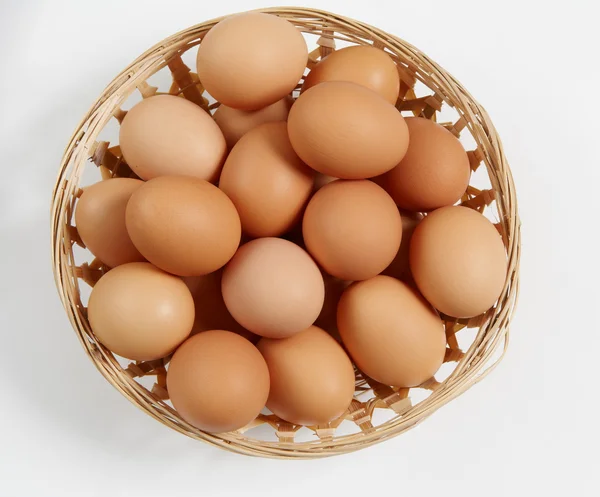 Basket of straw with eggs in white — Stock Photo, Image