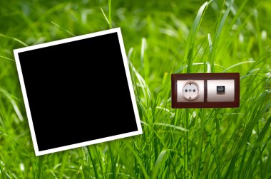 Energy outlet in grass with empty frame clipart