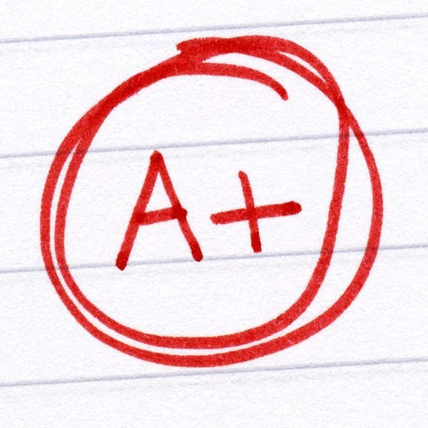 A + grade written on a test paper . — стоковое фото