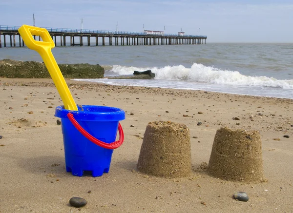 Kids bucket, spade and sandcastles. — Stock Photo, Image