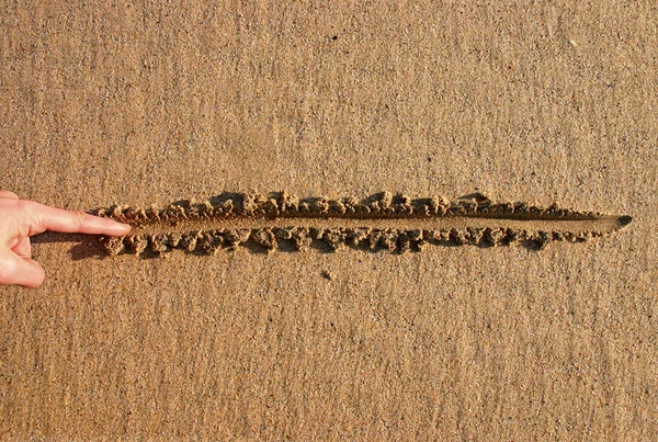 Kreslení čáry v písku. — Stock fotografie