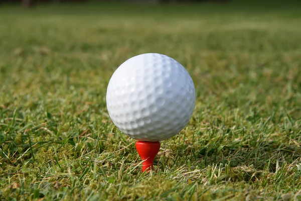 Ein Golfball auf einem roten Abschlag. — Stockfoto