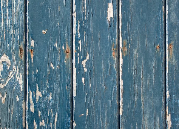 Blauwe vlokkig verf op een houten hek. — Stockfoto