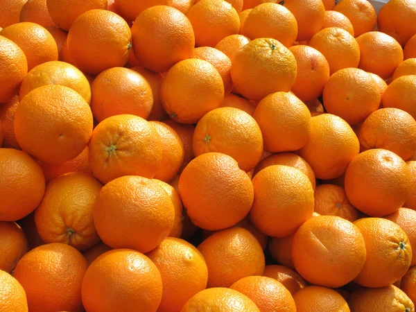 Massor av färska apelsiner frukt på nära håll. — Stockfoto