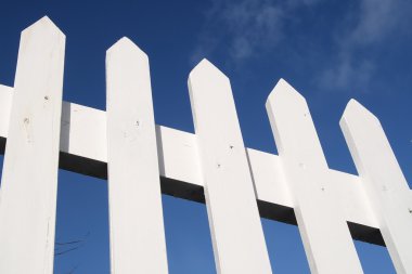 White picket fence and a blue sky. clipart