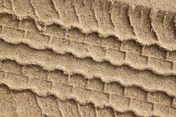 Detailní záběr pneumatiky stopy v písku. — Stock fotografie