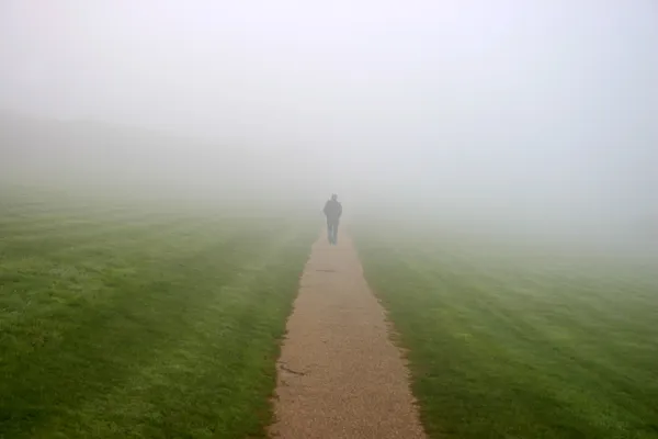 Человек, идущий в туман — стоковое фото