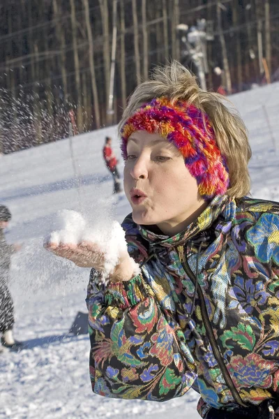 Die junge Frau pustet den Schnee — Stockfoto