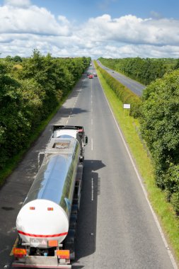 Truck with fuel tank on the highway clipart