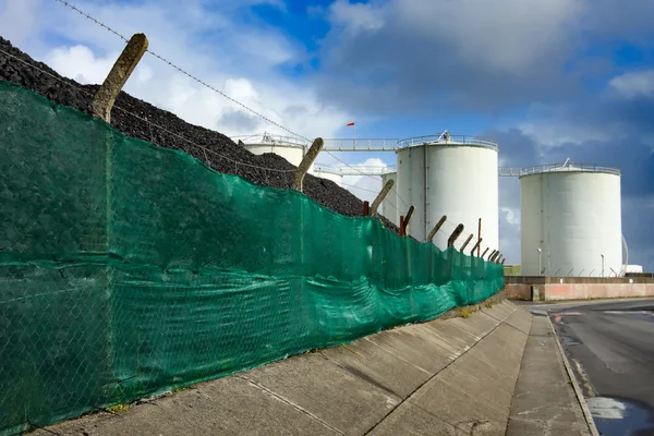 Coal heap and fuel tanks — Stok fotoğraf