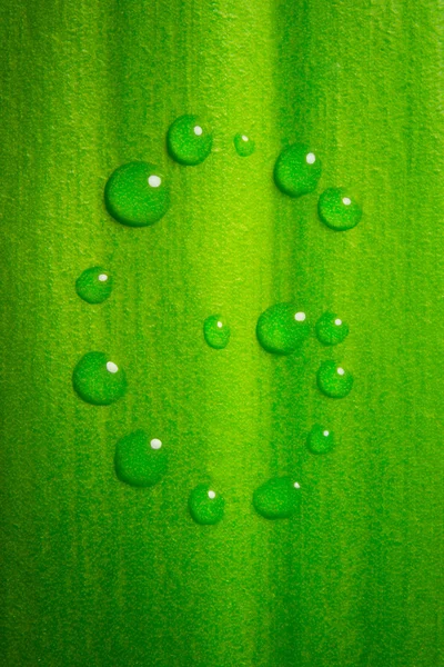 stock image G-shape water drops on green leaf