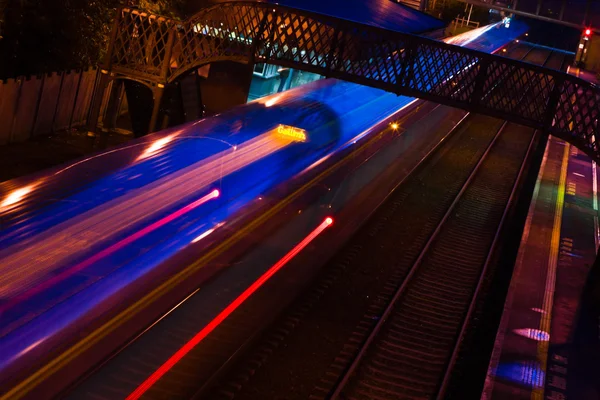 Comboio noturno em movimento com trilhas de luzes — Fotografia de Stock