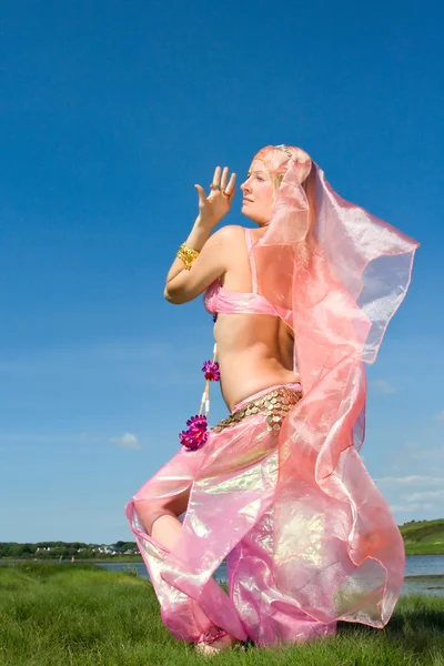 Mulher de rosa dançando na grama — Fotografia de Stock