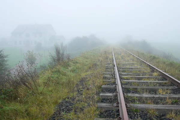 Vecchia ferrovia e casa che svanisce nella nebbia — Foto Stock