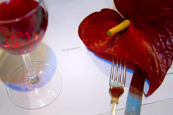 Kieliszek wina i czerwony kwiat — Zdjęcie stockowe