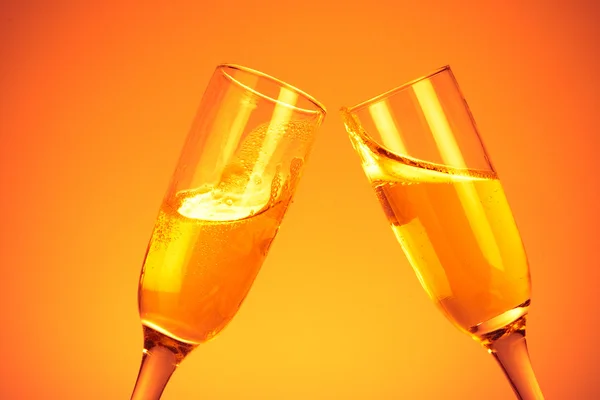 Pair of champagne flutes on orange backg — Stock Photo, Image