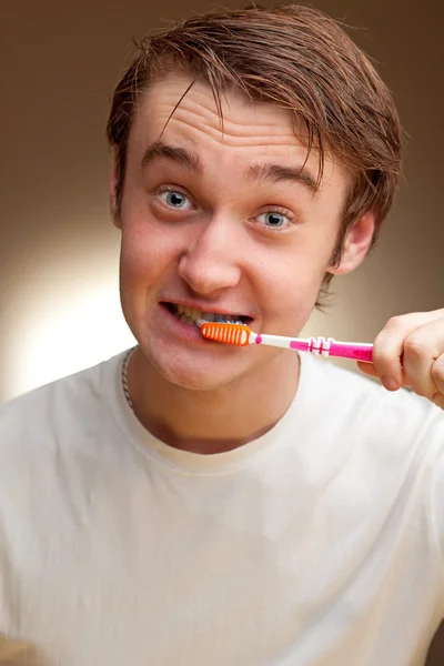 A funny young man cleans teeth. Toned. — Stock Photo, Image