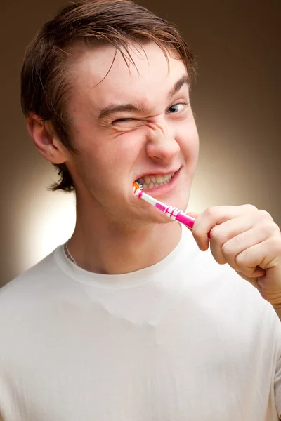 stock image A funny young man cleans teeth. Toned.