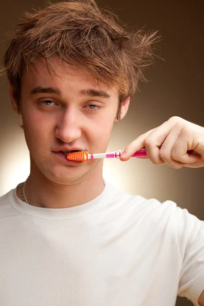 Sleepy young man cleans teeth — Stock Photo, Image