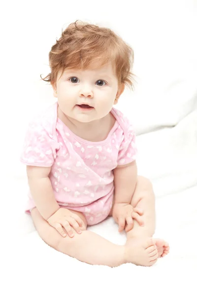 Маленькая девочка в розовой блузке на белом — стоковое фото
