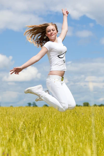 Meisje sprong in het veld — Stockfoto