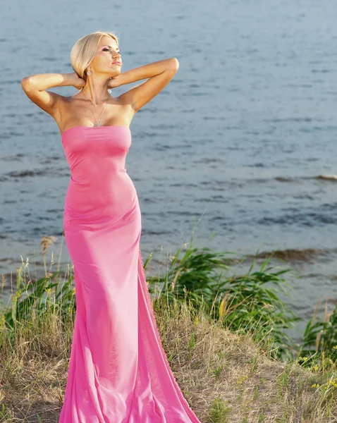Vacker flicka i en lång rosa klänning. — Stockfoto