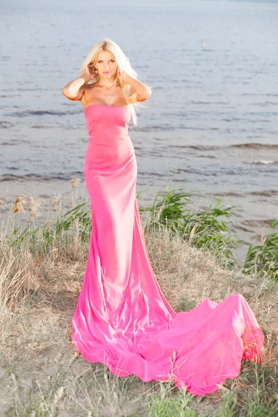 Schöne Mädchen in einem langen rosa Kleid. — Stockfoto