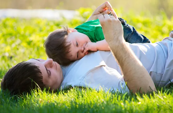 Отец и сын на траве — стоковое фото