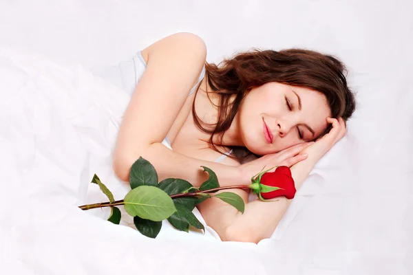 Menina dormindo na cama com rosa — Fotografia de Stock