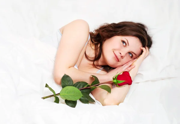 在与玫瑰的床上睡觉的女孩 — 图库照片