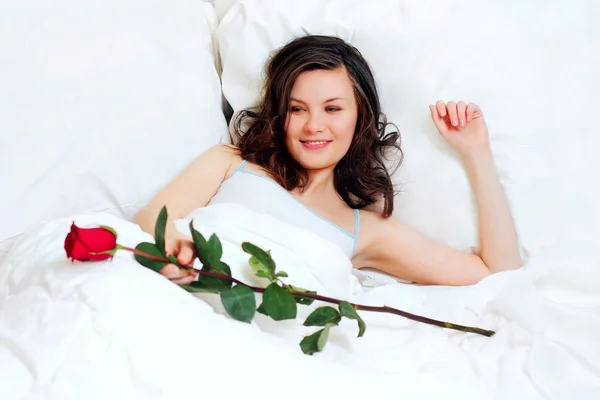 Flicka i sängen med ros — Stockfoto