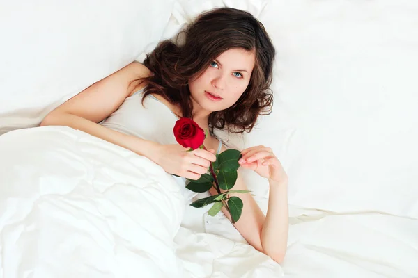 Menina na cama com rosa — Fotografia de Stock