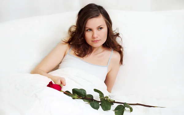 Holka v posteli s růží — Stock fotografie