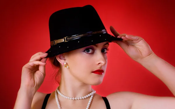 Jonge vrouw in zwarte hoed — Stockfoto